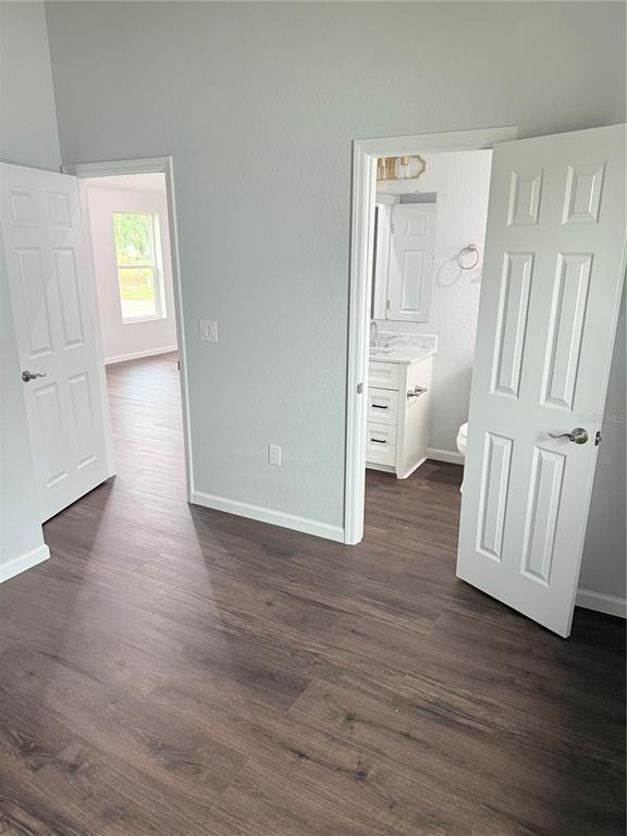 103 South Roger Avenue Arcadia, FL 34266 - Photo 12 of 22 an empty room with wooden floor and windows