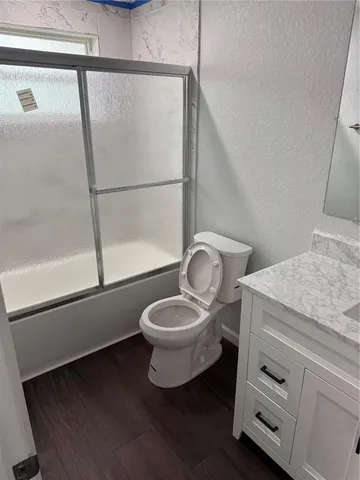 a spacious bathroom with a granite countertop sink toilet and a mirror