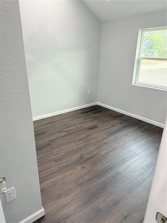 103 South Roger Avenue Arcadia, FL 34266 - Photo 22 of 22 an empty room with wooden floor and windows