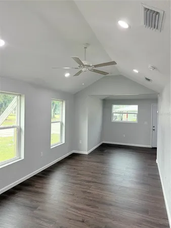 a view of an empty room window and wooden floor