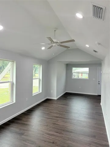 a view of an empty room window and wooden floor