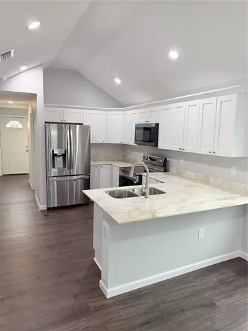 a kitchen with stainless steel appliances granite countertop a refrigerator stove microwave and sink