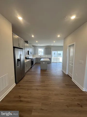 a kitchen with granite countertop a refrigerator stove top oven and sink