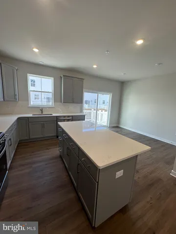 a large kitchen with stainless steel appliances kitchen island granite countertop a stove a refrigerator a sink a dining table and chairs