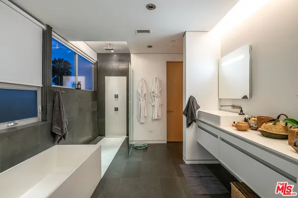 a bathroom with a tub sink and mirror