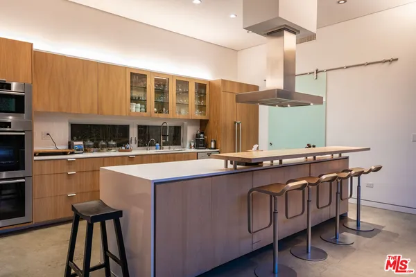 a kitchen with stainless steel appliances granite countertop a sink a stove and a refrigerator