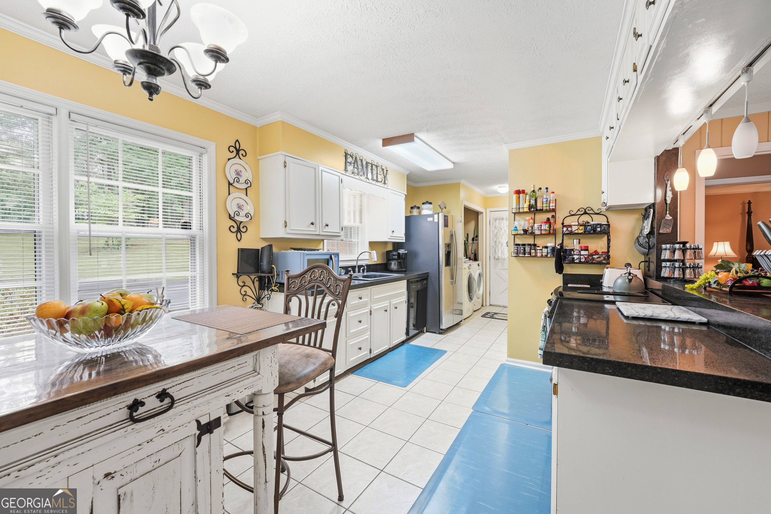 142 Tanglewood Road Southwest Eatonton, GA 31024 - Photo 12 of 50 a kitchen with stainless steel appliances granite countertop a stove top oven a sink a dining table and chairs with wooden floor