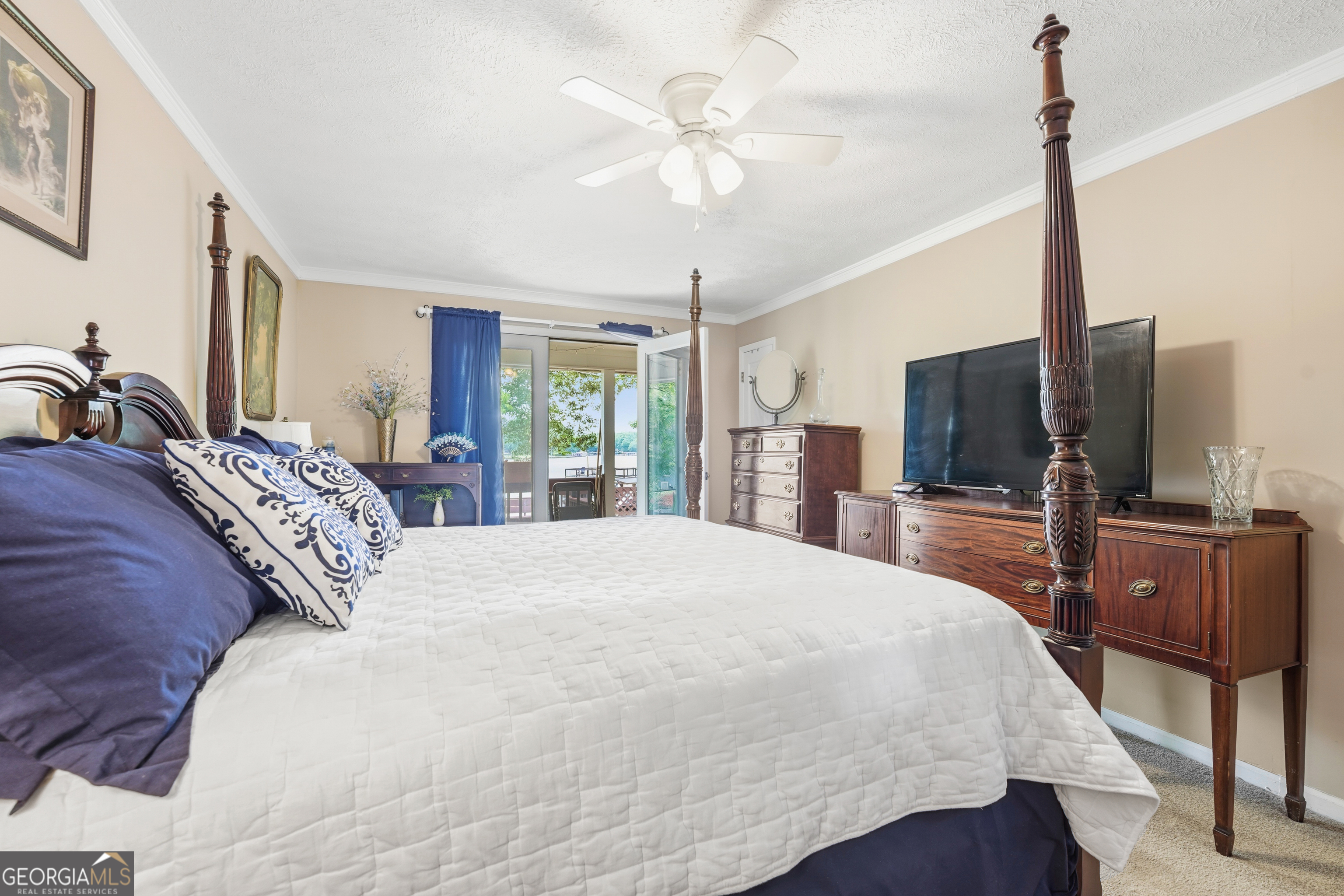 142 Tanglewood Road Southwest Eatonton, GA 31024 - Photo 20 of 50 a bedroom with a bed a large window and flat screen tv