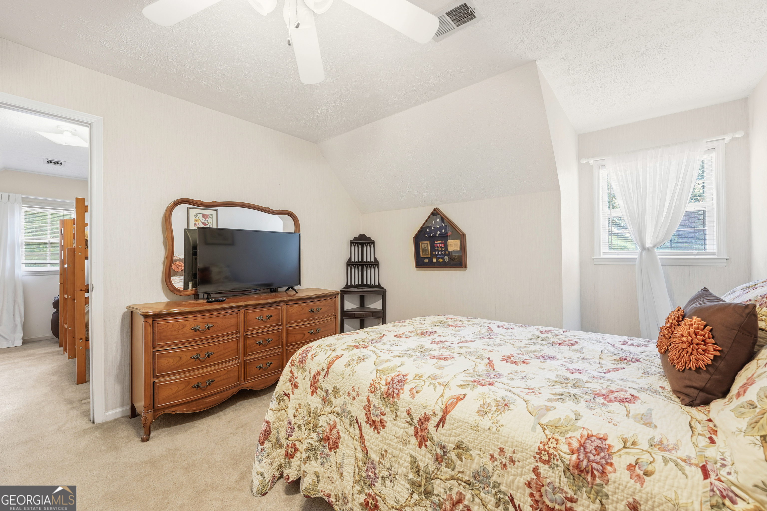 142 Tanglewood Road Southwest Eatonton, GA 31024 - Photo 25 of 50 a bedroom with a large bed and a flat screen tv
