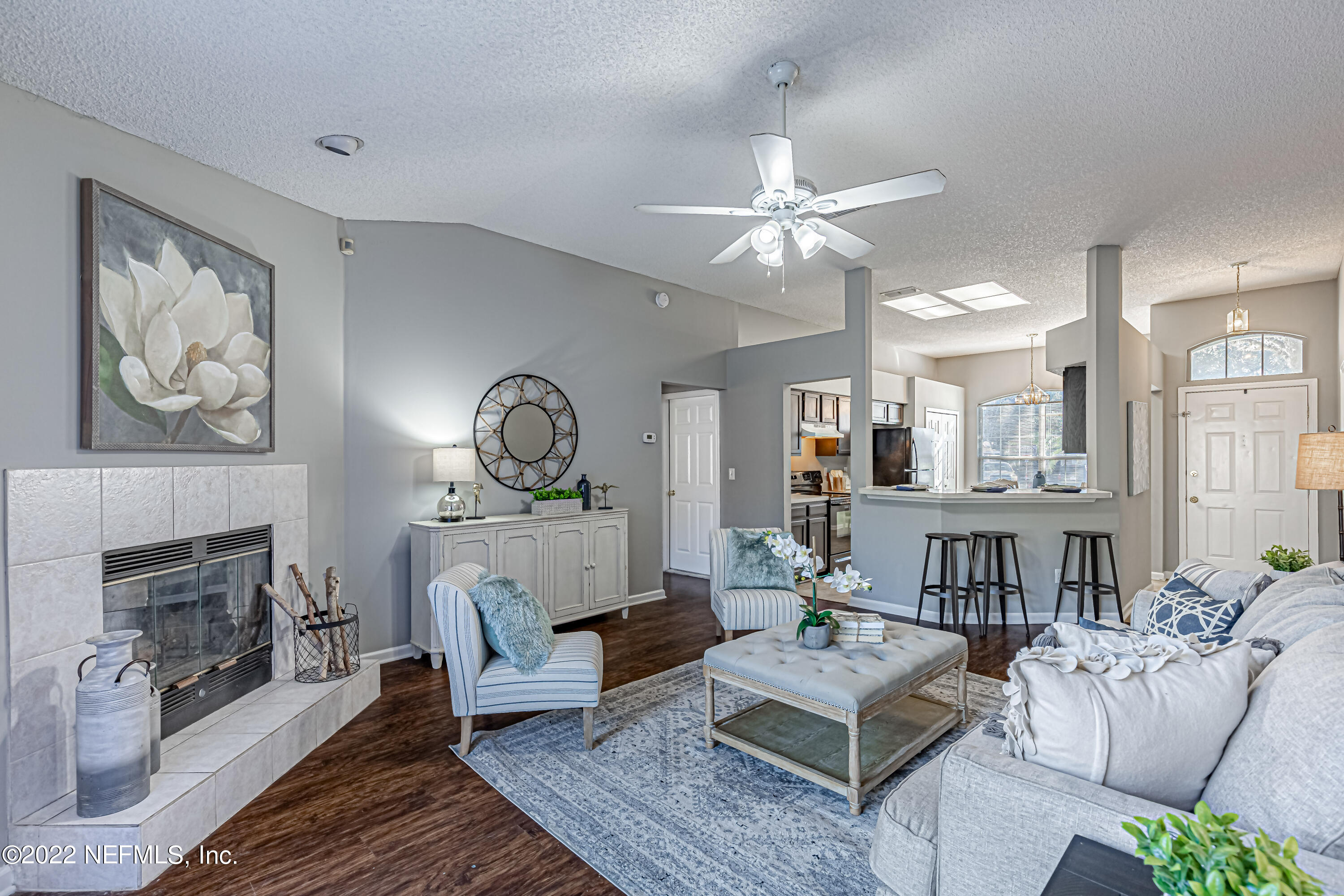 7696 Enderby Avenue East Jacksonville, FL 32244 - Photo 18 of 35 a living room with furniture a fireplace and a chandelier