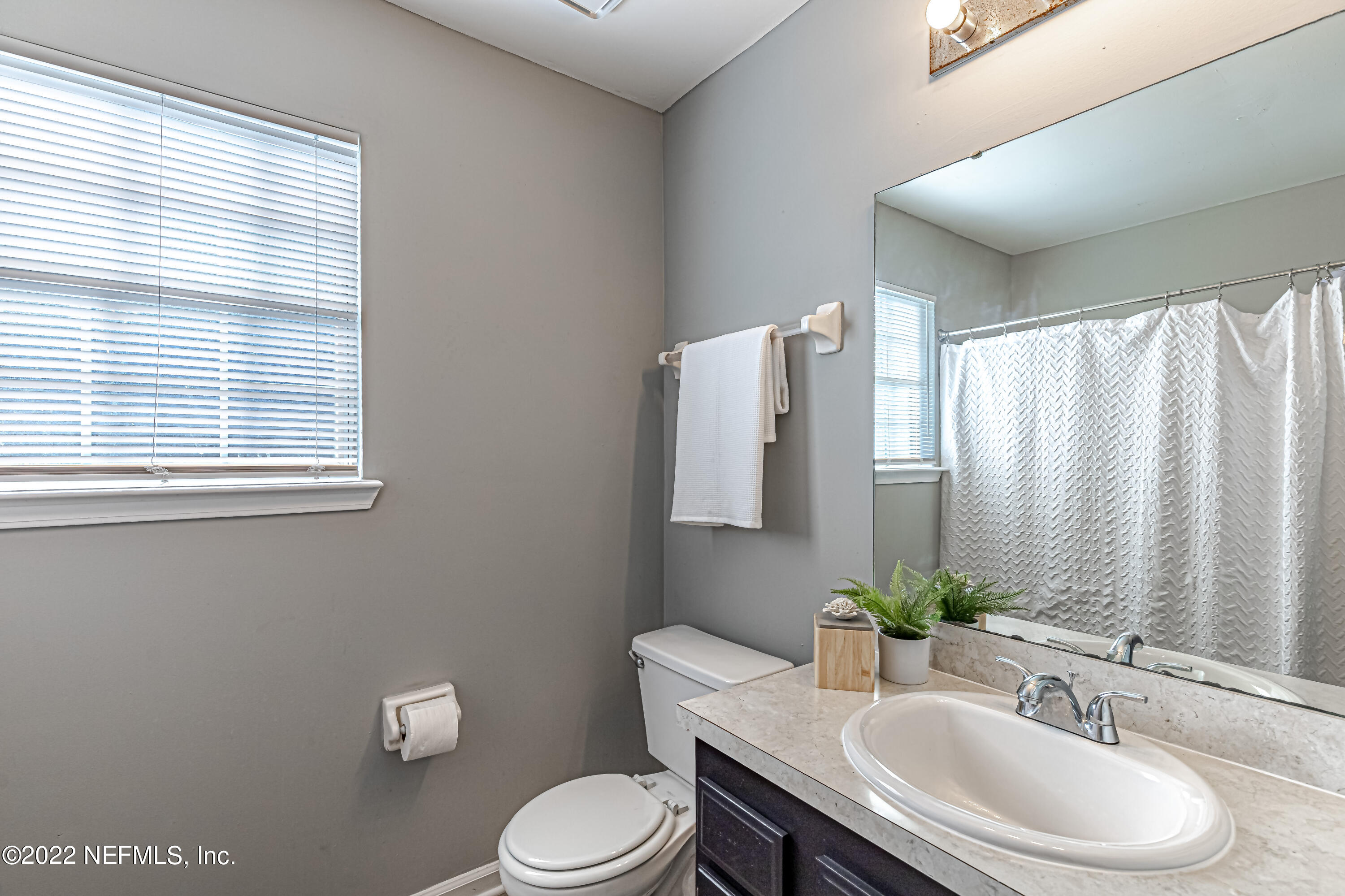 7696 Enderby Avenue East Jacksonville, FL 32244 - Photo 20 of 35 a bathroom with a granite countertop sink vanity mirror and toilet