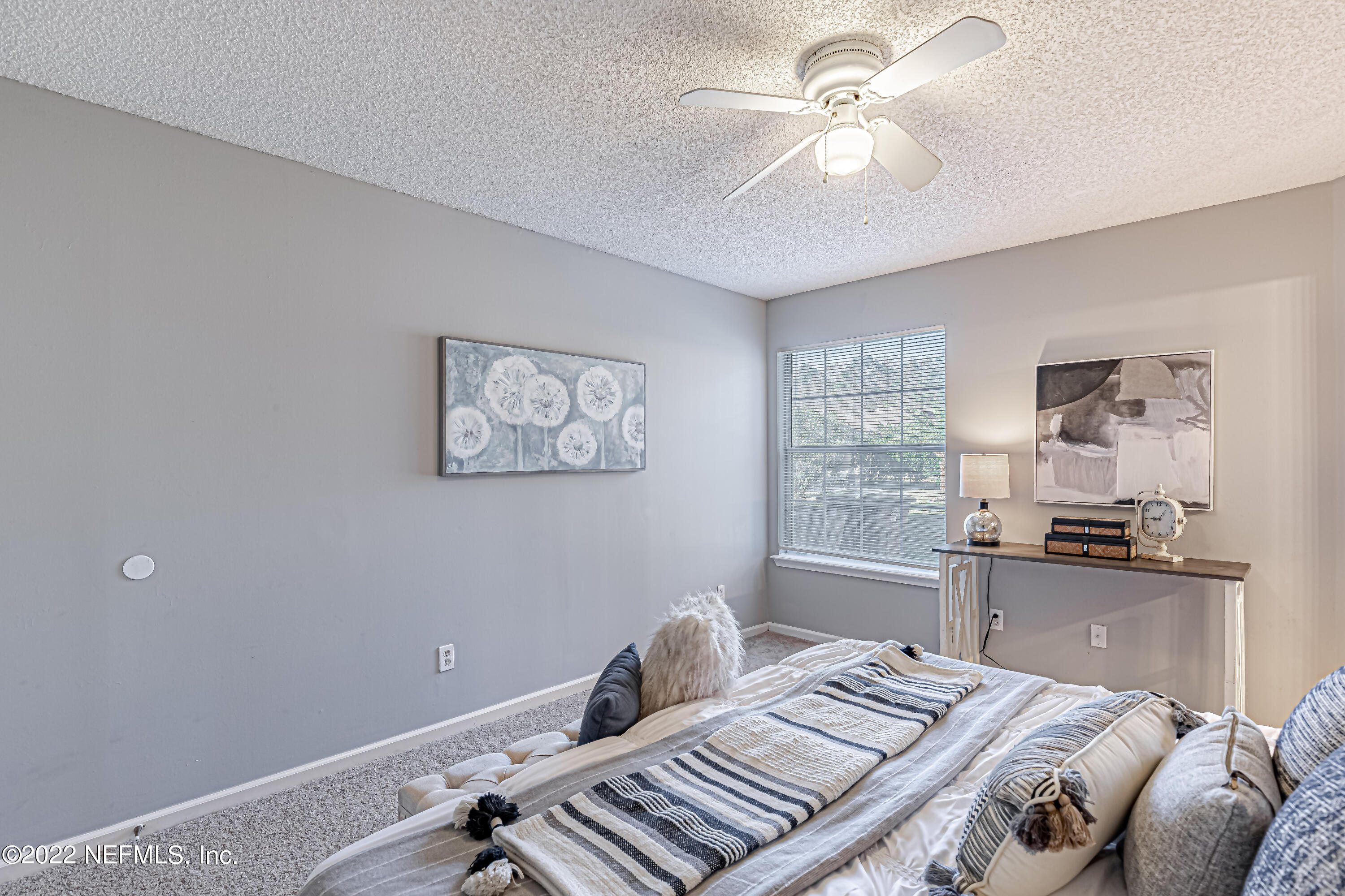 7696 Enderby Avenue East Jacksonville, FL 32244 - Photo 23 of 35 a bedroom with a bed and a chandelier