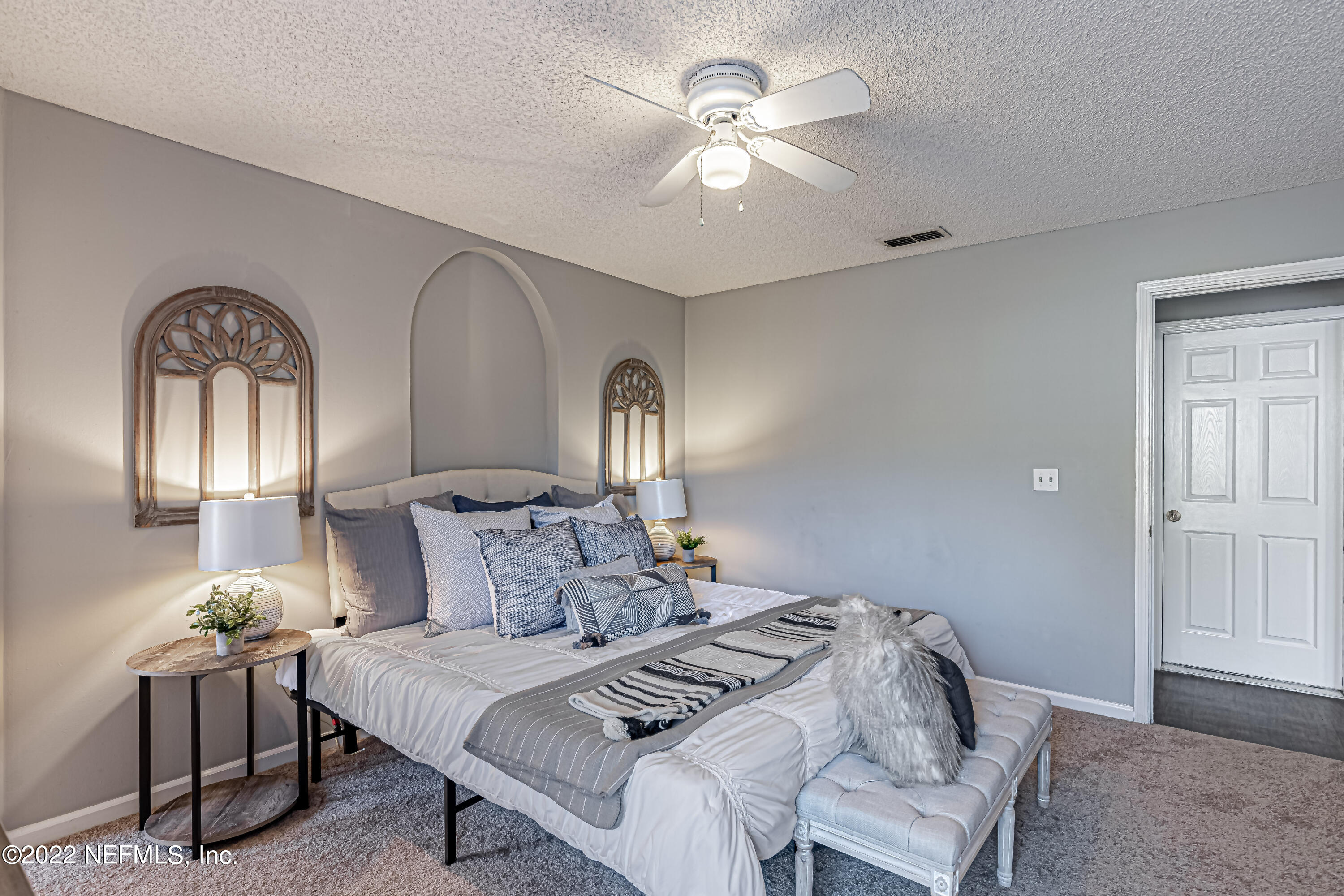 7696 Enderby Avenue East Jacksonville, FL 32244 - Photo 24 of 35 a bedroom with a bed and a chandelier