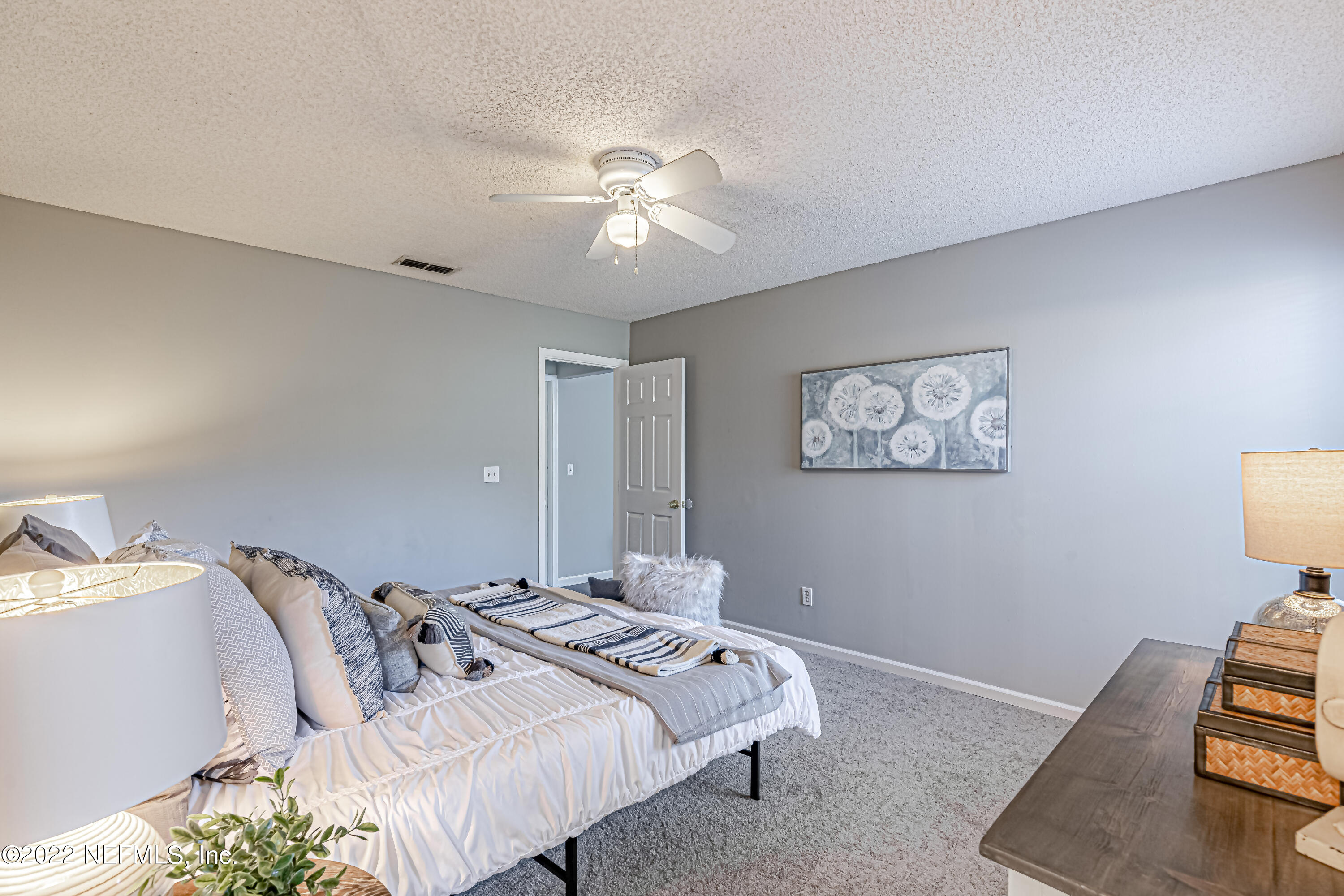 7696 Enderby Avenue East Jacksonville, FL 32244 - Photo 25 of 35 a bedroom with a bed and a chandelier