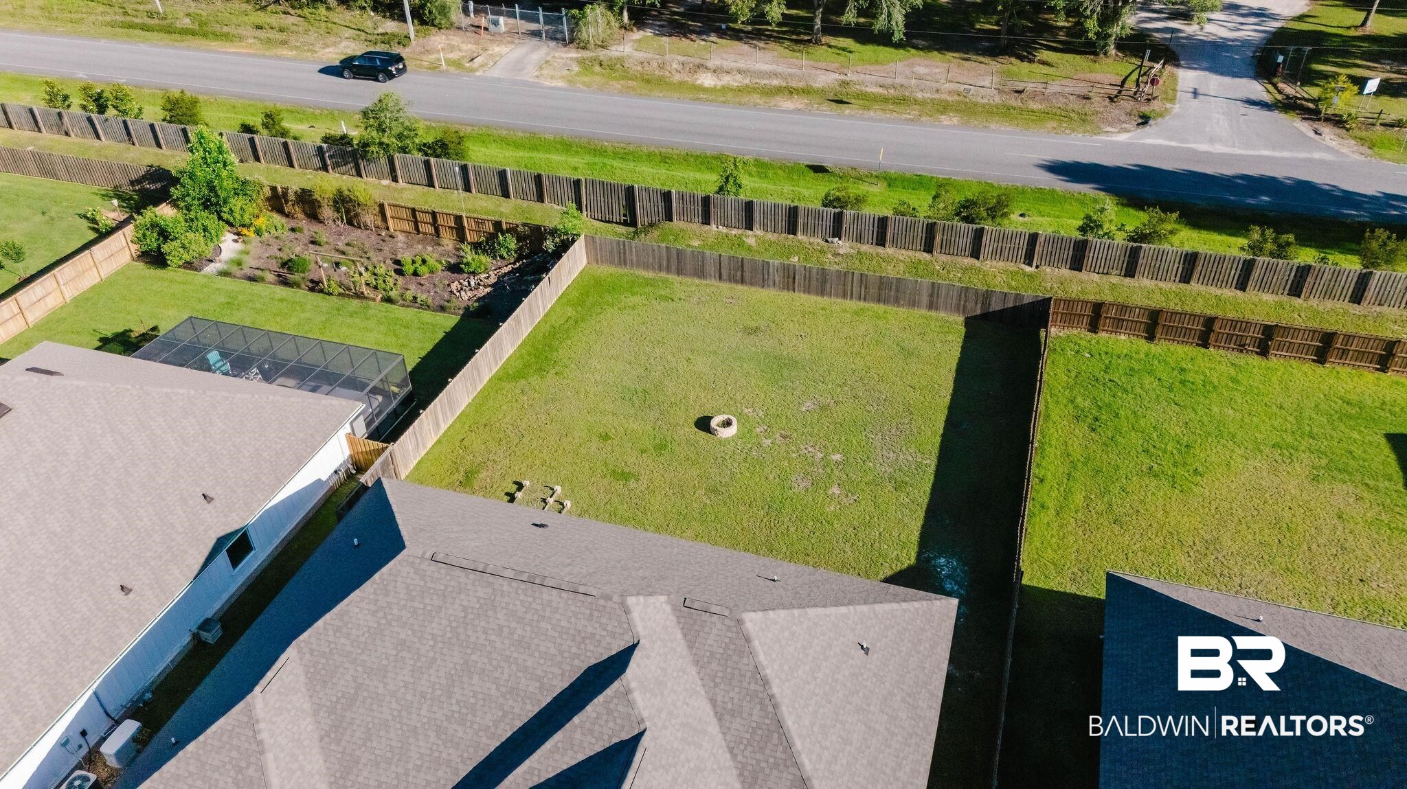7872 Calverton Street Foley, AL 36535 - Photo 68 of 76 Expansive rear yard featuring a large grass area, wood privacy fencing, and a fire pit