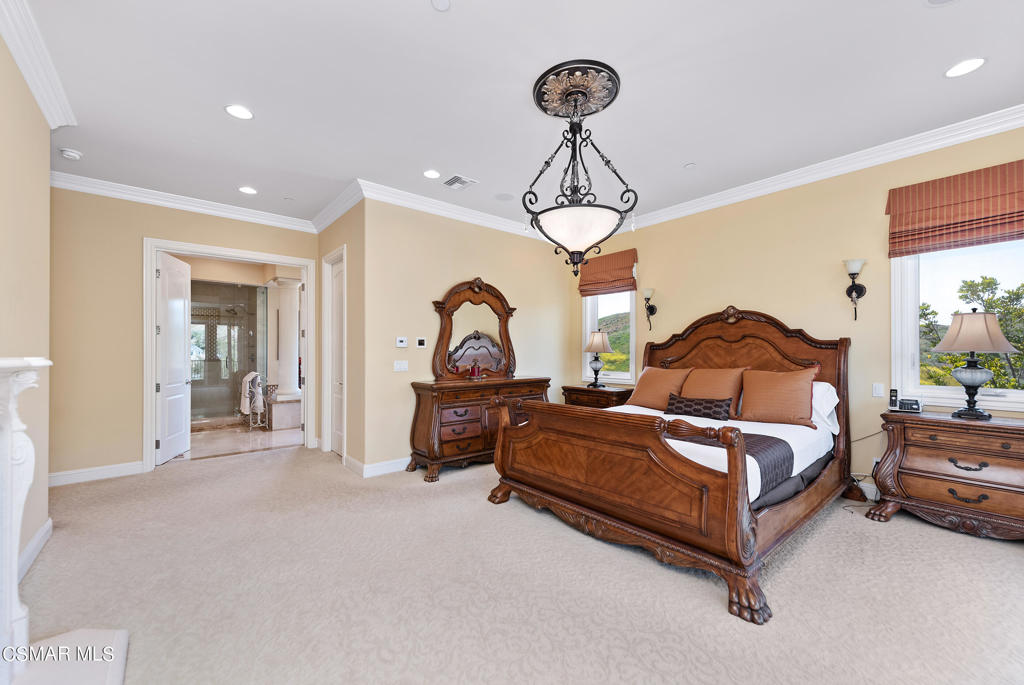 2462 Lost Canyons Drive Simi Valley, CA 93065 - Photo 34 of 50 a spacious bedroom with a bed a chandelier and glass door