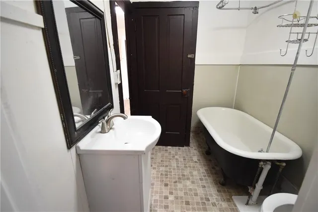 a bathroom with a sink a toilet a mirror and bathtub