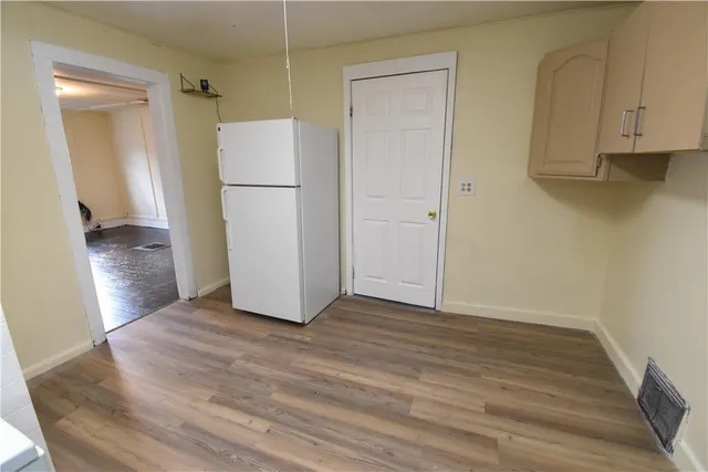 an empty room with wooden floor and a sink