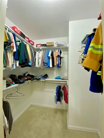 a view of walk in closet with clothes and shoes