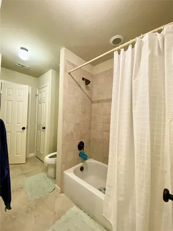 a bathroom with a tub shower and a sink