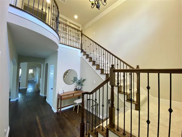 a view of a hallway with wooden floor and stairs
