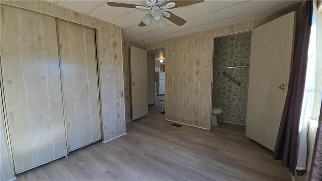 a view of a hallway with wooden floor and closet area