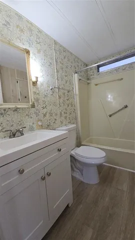 a bathroom with a granite countertop sink a toilet and a shower