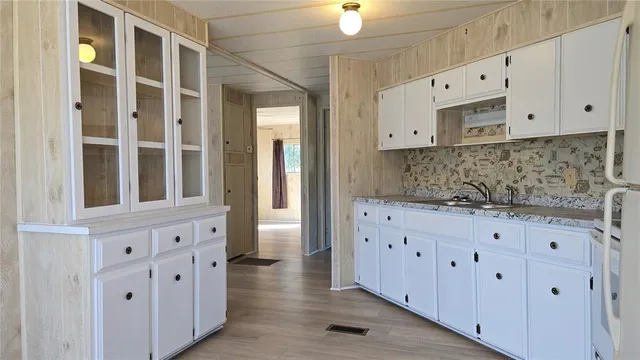 a kitchen with granite countertop white cabinets and white appliances