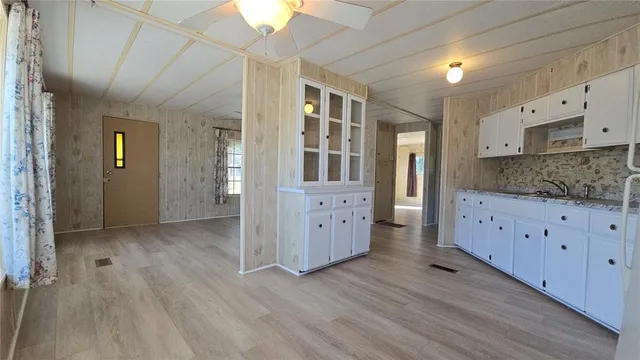 a view of a kitchen with furniture and wooden floor