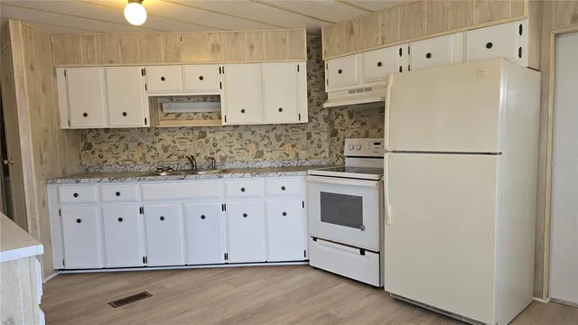 a white refrigerator freezer sitting in a kitchen