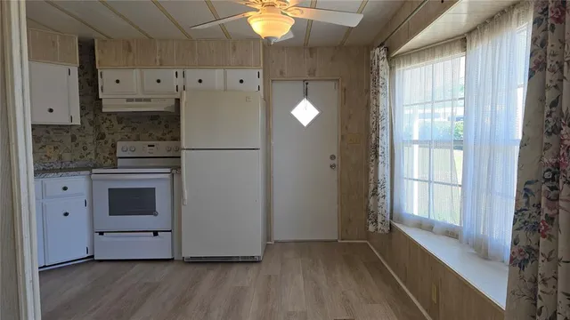 a kitchen with cabinets and wooden floor