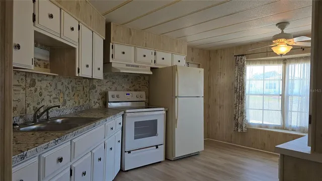 a kitchen with cabinets a window and stainless steel appliances