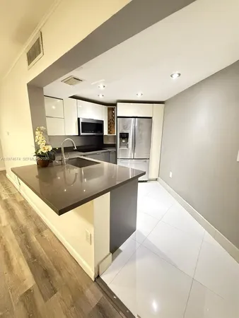 a large kitchen with kitchen island a sink stainless steel appliances and cabinets