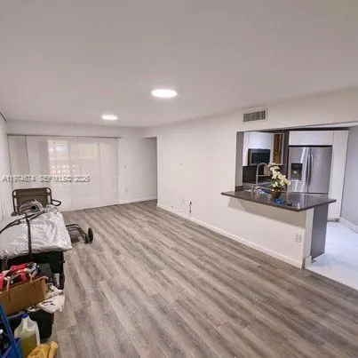 a view of a living room kitchen and a wooden floor
