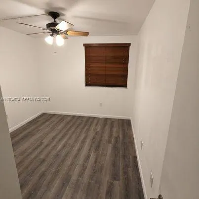 a view of a room with wooden floor and a ceiling fan