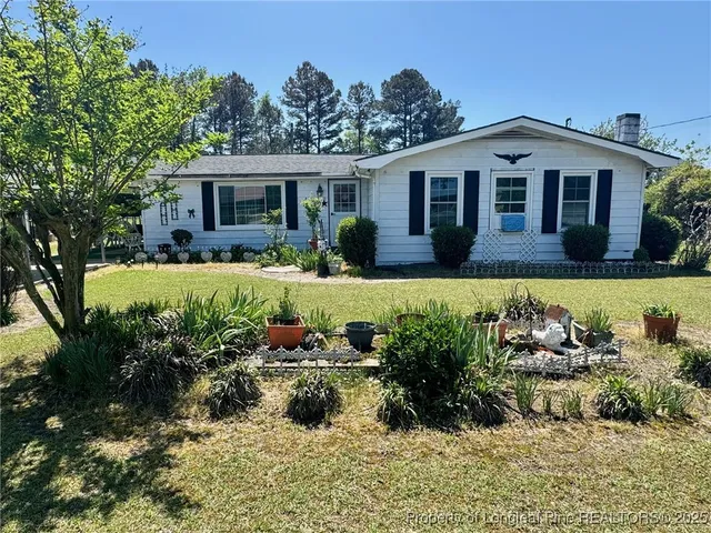 a view of a house with a yard and sitting area