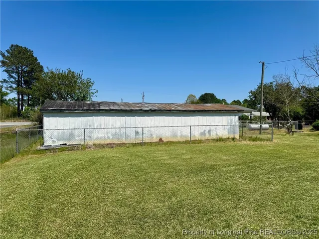 a view of a big yard with a house in the background