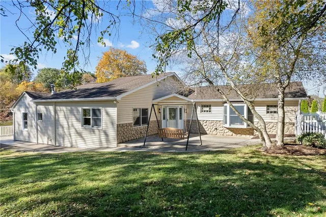 a view of a house with backyard and sitting area