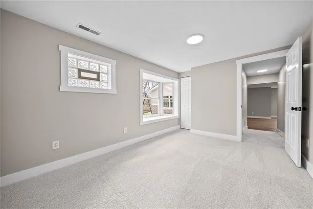 an empty room with windows and closet