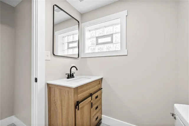 a bathroom with a sink a vanity and a window