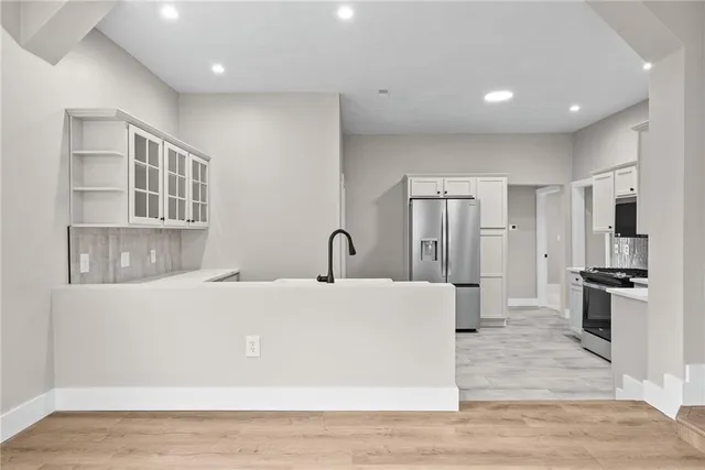 a large white kitchen with stainless steel appliances