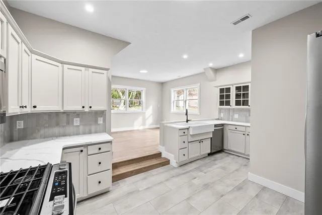 a kitchen that has a lot of cabinets in it and wooden floors
