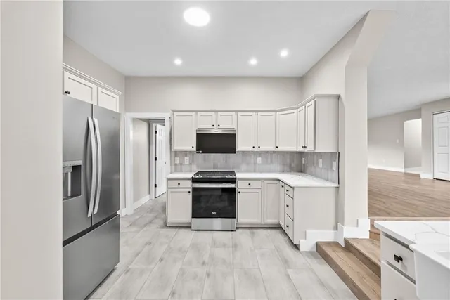 a large kitchen with cabinets stainless steel appliances and a counter space