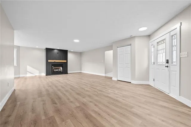 a view of empty room with a fireplace and wooden floor