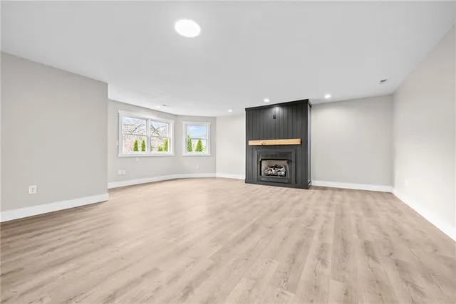 an empty room with windows and fireplace