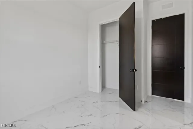a kitchen with white cabinets and refrigerator