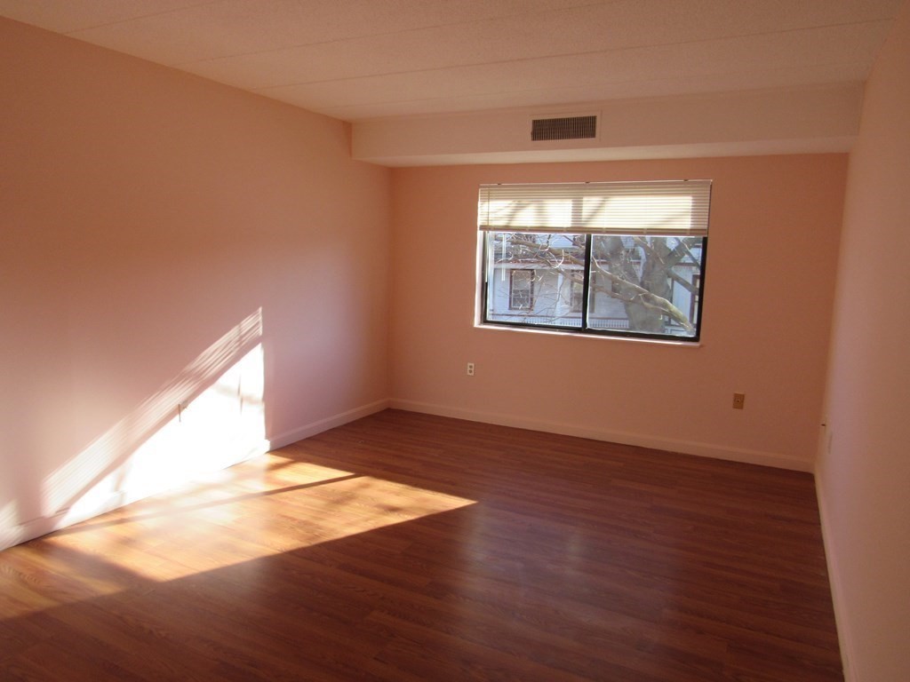 8 Nahant Place, Unit 202 Lynn, MA 01902 - Photo 11 of 24 an empty room with wooden floor and windows