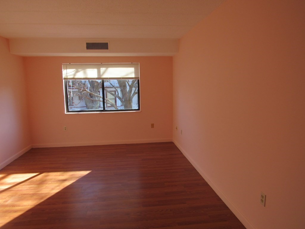 8 Nahant Place, Unit 202 Lynn, MA 01902 - Photo 13 of 24 an empty room with wooden floor and windows