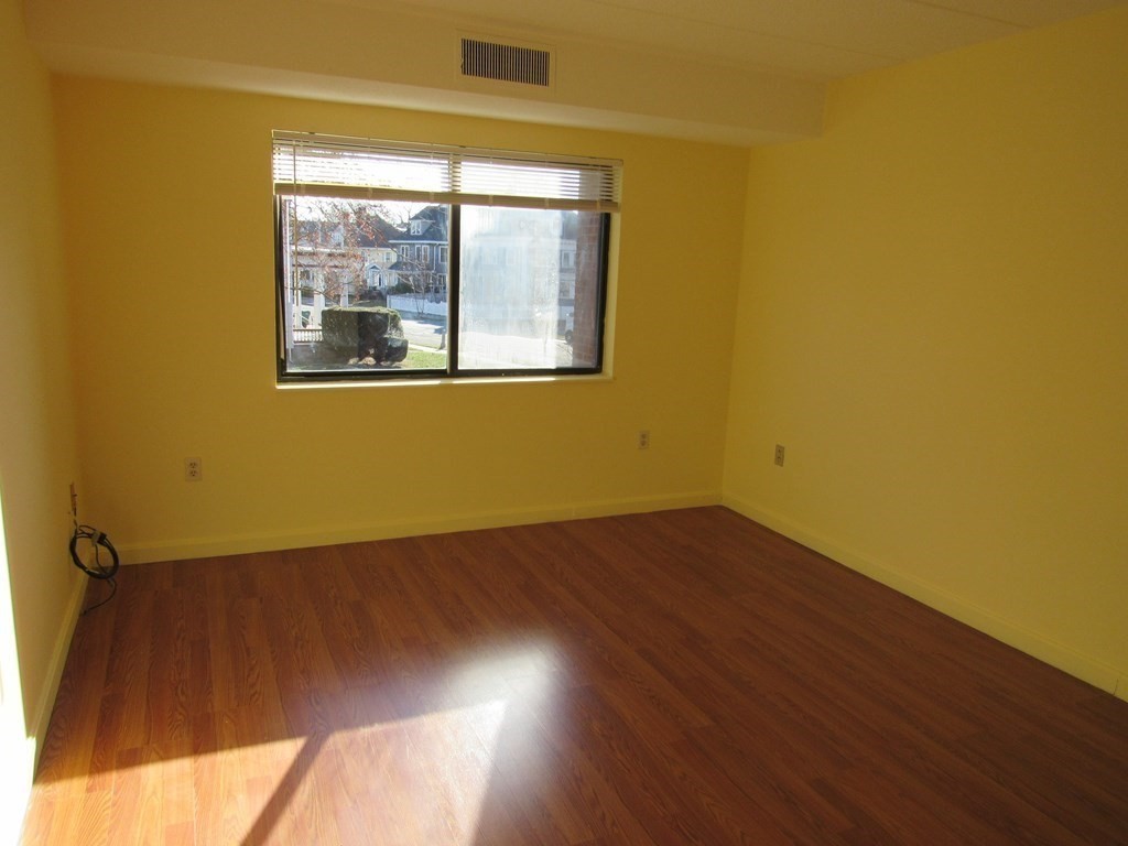 8 Nahant Place, Unit 202 Lynn, MA 01902 - Photo 16 of 24 a view of an empty room with wooden floor and a window