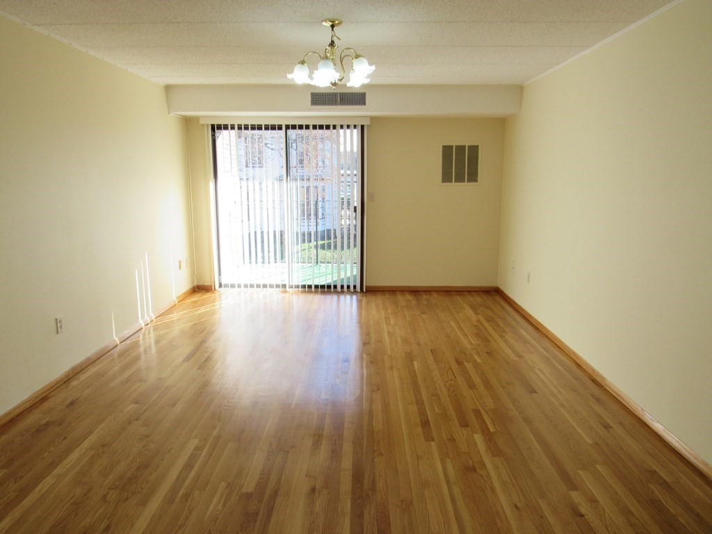 8 Nahant Place, Unit 202 Lynn, MA 01902 - Photo 4 of 24 wooden floor in an empty room with a window